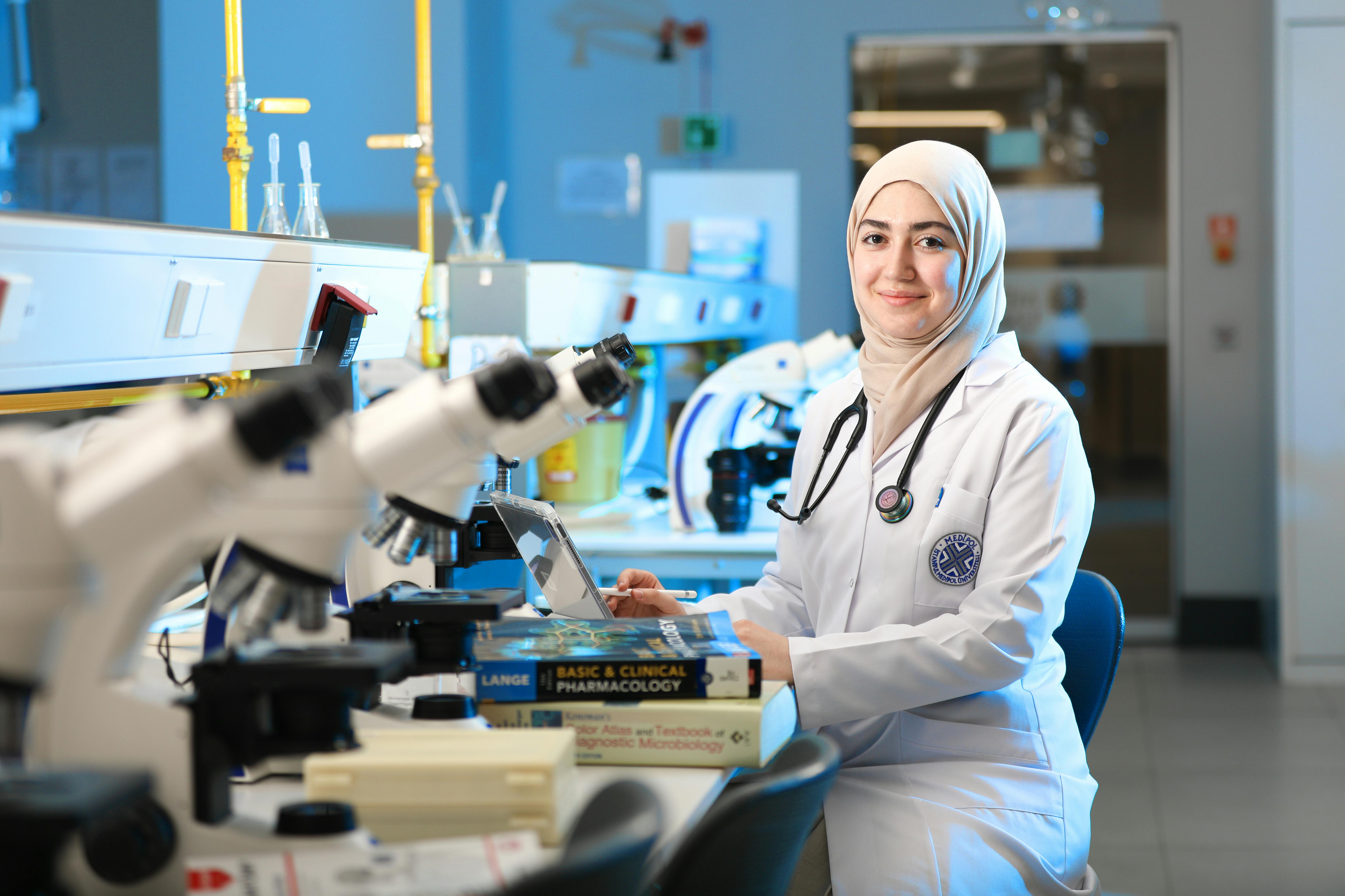 Researcher working in a parasite laboratory with high-throughput screening equipment and sample plates.